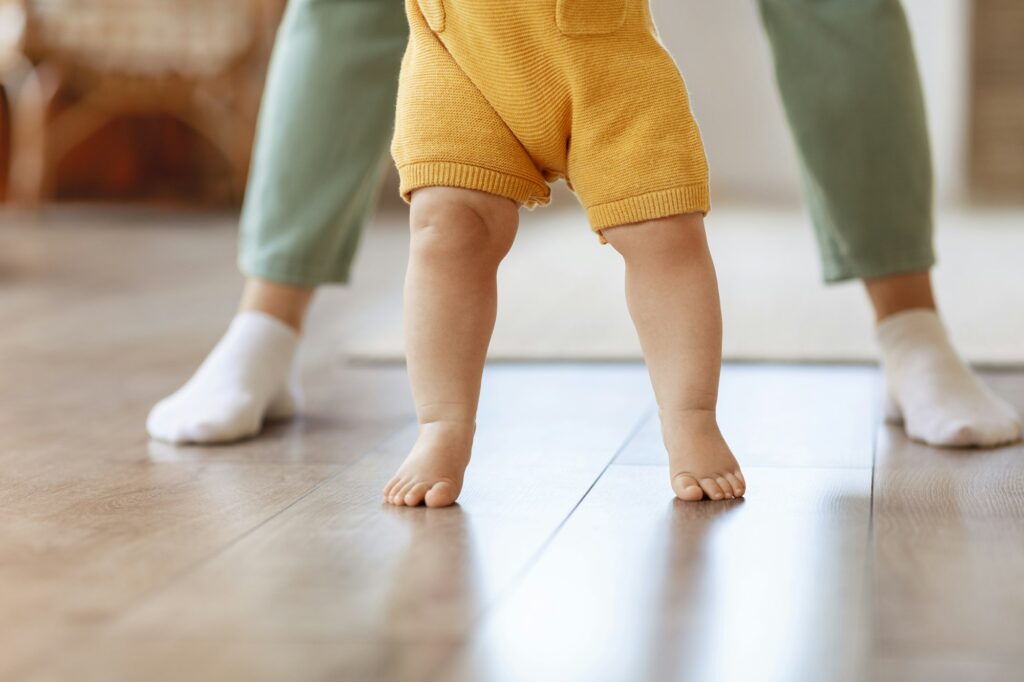 Little baby kid child learn walking in home with mother