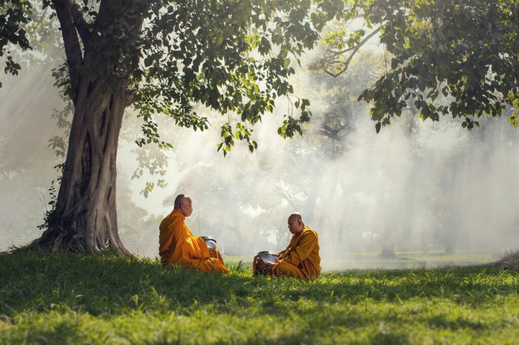 Two monks meditation under the trees with sun ray, Buddha religion concept